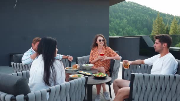 积极的跨国朋友们在阳台上的山区度假胜地喝着鸡尾酒 在餐馆里聊天 — 图库视频影像