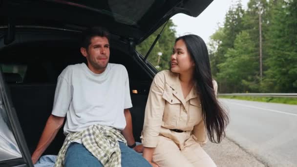 Zamyślona Międzynarodowa Para Rozmawiająca Bagażniku Samochodu Górach — Wideo stockowe