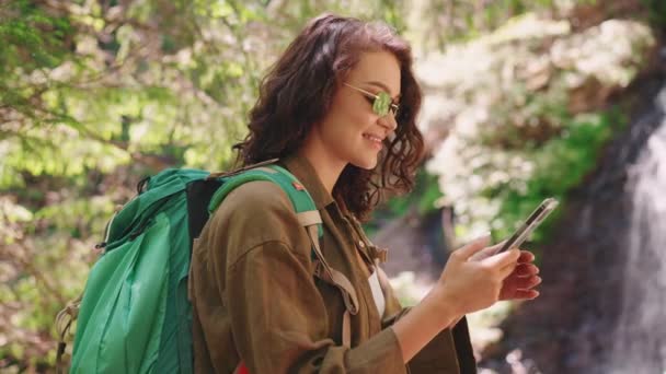 Smiling Tourist Woman Sunglasses Texting Phone Waterfall Mountain — Stok Video