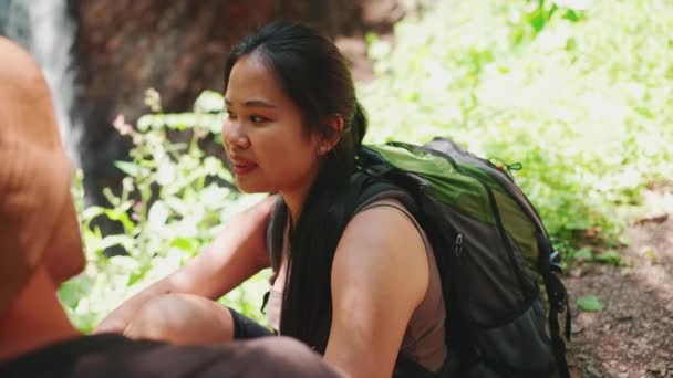 Щаслива Багатонаціональна Туристична Пара Розмовляє Біля Водоспаду Горах — стокове відео