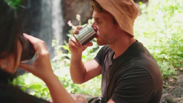 Relaksująca Się Międzynarodowa Para Turystów Pije Herbatę Termosu Rozmawia Nad — Wideo stockowe