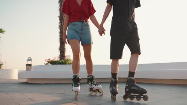 Paar Hand Hand Terwijl Rolschaatsen Bij Zonsondergang Door Zee — Stockvideo