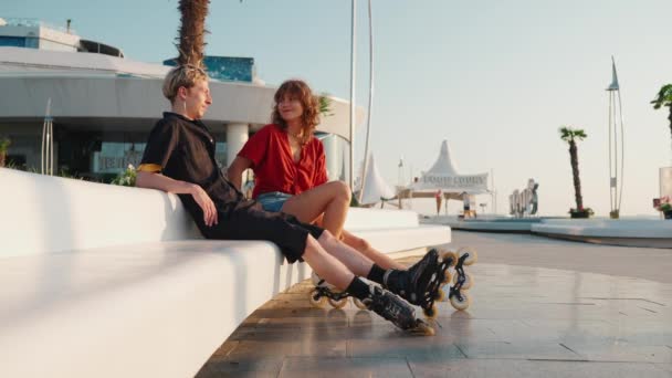 Glimlachend Jong Paar Praten Rolschaatsen Zonsondergang Door Zee — Stockvideo
