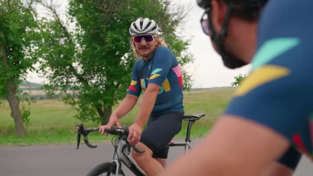 Zwei Positive Männliche Triathleten Ruhen Sich Nach Rennradfahren Sommer Aus — Stockvideo