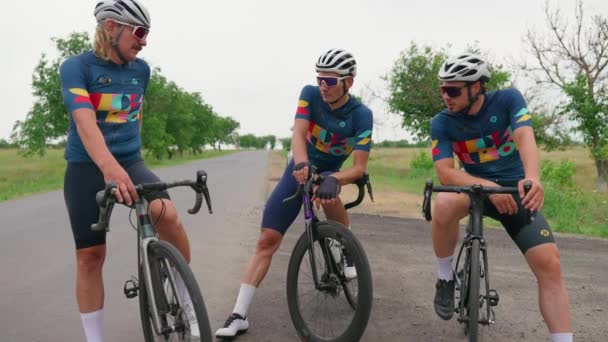 Drei Gut Aussehende Männliche Triathleten Rasten Sommer Nach Rennrädern — Stockvideo
