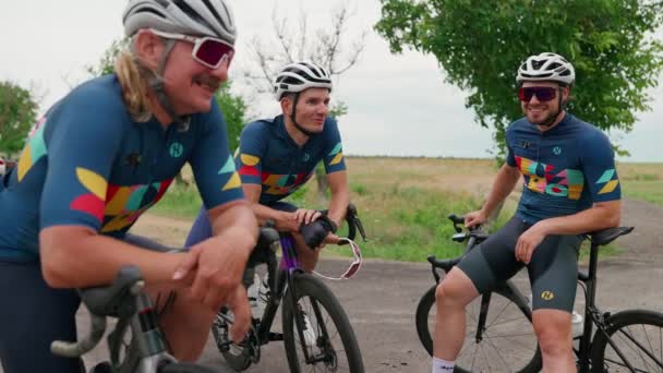 三个快乐的男子自行车手在夏天骑完自行车后休息一下 — 图库视频影像
