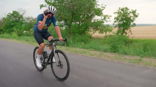 Kendine Güvenen Sarışın Atletik Erkek Bisikletçi Yolda Bisiklet Sürüyor Içiyor — Stok video
