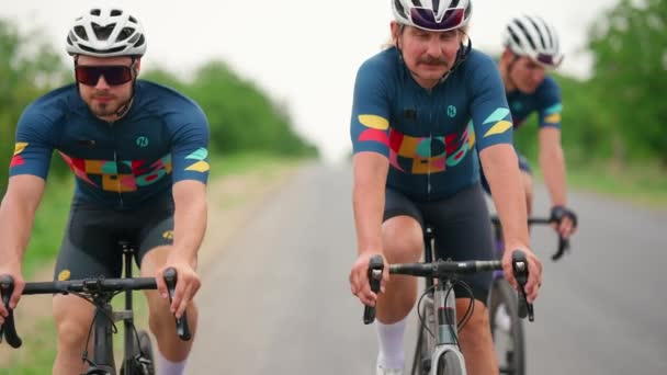 Drei Niedliche Athletische Männer Radeln Mit Dem Fahrrad Auf Der — Stockvideo