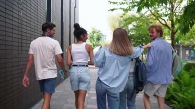 Yaz mevsiminde üniversitenin yanında konuşan ve yürüyen çok uluslu sevimli genç öğrencilerin arka plan görüntüsü