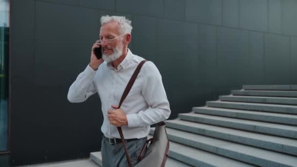 屋外で働く方法で携帯電話で話すスーツで陽気な古いビジネスマン — ストック動画