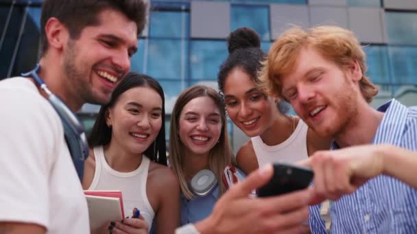 Nevető Multinacionális Fiatal Diákok Beszélnek Nézik Mobiltelefonokat Miközben Nyáron Egyetem — Stock videók