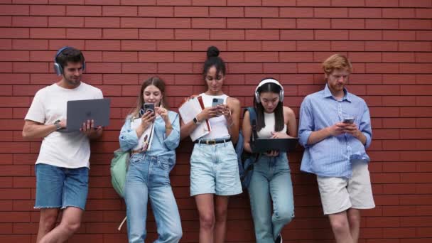 Zelfverzekerde Multiculturele Jonge Studenten Typen Telefoons Laptops Buurt Van Bakstenen — Stockvideo
