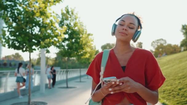 Positieve Afrikaanse Vrouw Met Rugzak Die Muziek Luistert Een Koptelefoon — Stockvideo