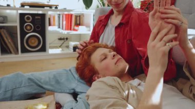 Saçları boyalı, gülümseyen geyler evde yerde fal bakıyorlar.