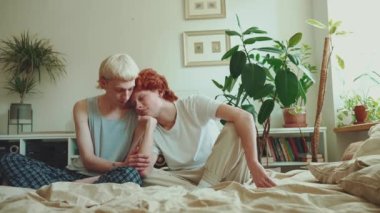 Üzgün, saçları boyalı, evde yatakta eğlenen genç eşcinsel çift.
