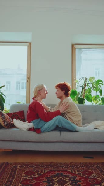 幸せな若いゲイカップルと染められた髪のハグして自宅でソファーで話す — ストック動画