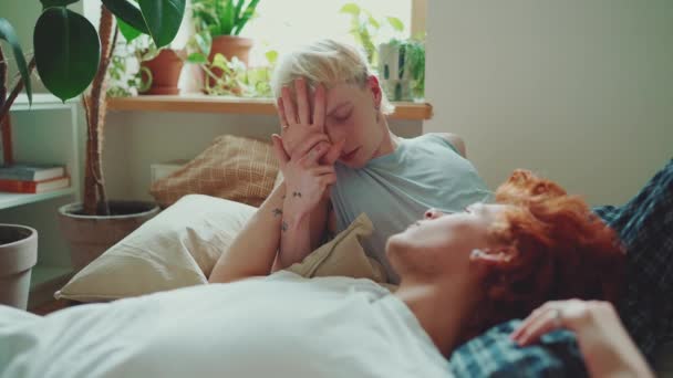 自信を持って若いゲイカップルと染められた髪の話と朝の自宅でベッドに手を握る — ストック動画
