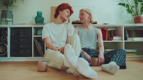 Szczęśliwy Młody Gej Para Farbowane Włosy Rozmowy Podłogi Wewnątrz — Wideo stockowe