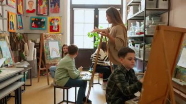 Konsantre çocuklar resim çizmeyi ve bir sanat okulunda bir öğretmenle konuşmayı öğrenirler.