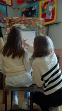 Sanat okulunda resim dersinde resim yapan konsantre genç kızların arka plan görüntüsü