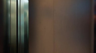 Ofis asansöründe konuşan çok uluslu meslektaşlar.
