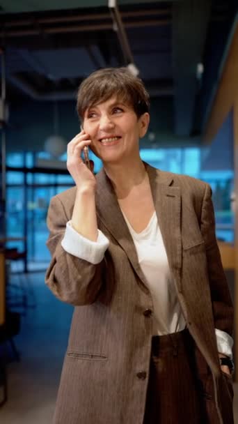 Yakışıklı Esmer Olgun Bir Kadını Ofiste Cep Telefonuyla Konuşuyor — Stok video