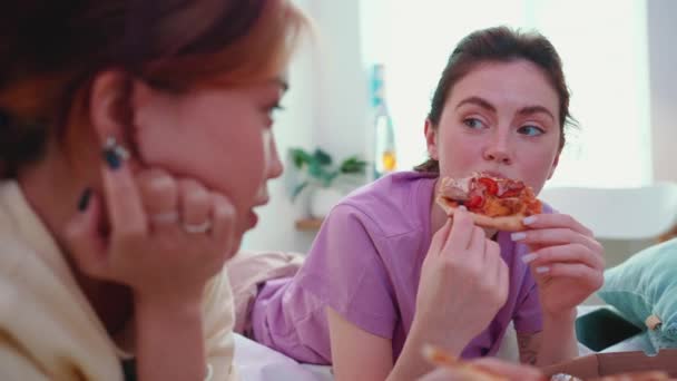 Весёлые Многонациональные Девушки Разговаривают Едят Пиццу Кровати Время Ночевки — стоковое видео