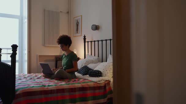 Продумана Африканська Жінка Окулярах Кучеряве Волосся Працює Ноутбуці Ліжку Дому — стокове відео