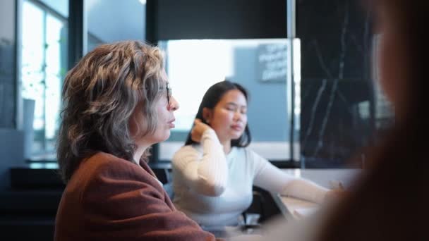 积极的灰发女商人在办公室会议上与多国同事讨论工作计划 — 图库视频影像