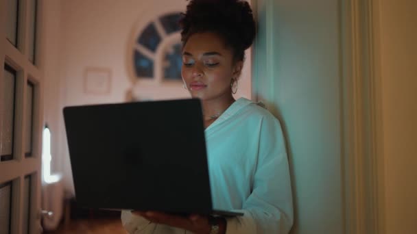 晚上在家里用笔记本电脑工作的英俊的非洲女人 — 图库视频影像