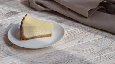 Cheesecake 'ten bir ısırık alıyorum. Klasik New York peynirli kek dilimi, çatalla yemek.