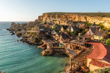 Anchor Bay, Mellieha, Malta 'daki ünlü Temel Reis Köyü. Turkuaz deniz suyu ve mavi gökyüzü.