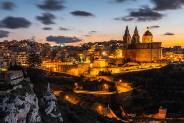 Il-Mellieha, Malta - illuminated Mellieha town at blue hour with Paris Church on hill top.