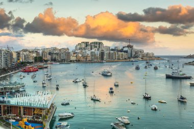 Sunset over Sliema Bay in Malta. Clouds and boats.