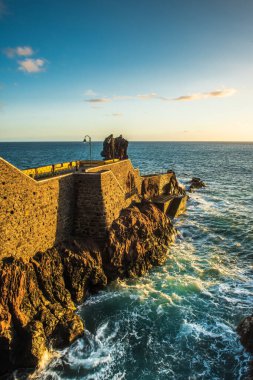 Ponta do Sol 'da kayalar, Madeira sahilinde uçurumlarda gezinti. Gün batımı ışığı, Atlantik Okyanusu dalgaları