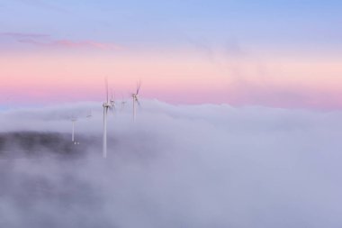 Rüzgar türbinleri tepede Sabah sisinde gün doğumunda