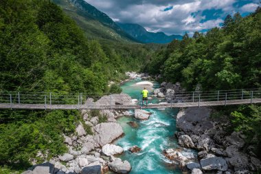 SLovenia 'daki Soca Alp Nehri' ndeki asma köprüde yürüyen aktif bir adam.