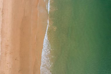 Algarve, Portekiz kıyı şeridi, kumlu sahil, Atlantik Okyanusu dalgaları ve gün batımında kızıl kayalıklar. Hava aracı görünümü.