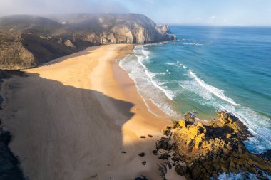 Kumlu kumsal ve Portekiz 'in Atlantik Okyanusu kıyısındaki dramatik uçurumlar. Hava aracı görünümü
