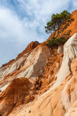 Güneşli bir günde Portekiz, Algrave 'deki kumlu sahilde kızıl kayalıklar