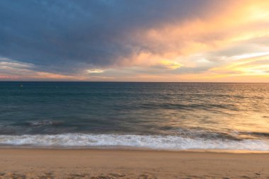 Portekiz 'in Altantic Okyanusu kıyısındaki kumlu sahilde gün batımı