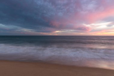 Portekiz 'in Altantic Okyanusu kıyısındaki kumlu sahilde gün batımı
