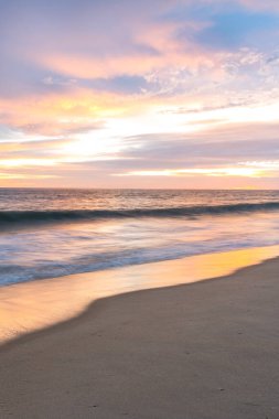 Portekiz 'de kumlu plajlı okyanus günbatımında bulutlu manzara ve deniz manzarası