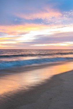 Portekiz 'in Altantic Okyanusu kıyısındaki kumlu sahilde gün batımı
