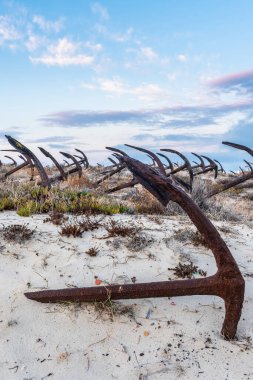 Praia do Barril sahilindeki Anchor Mezarlığı 'nın sahilindeki paslı eski çapalar Tavira, Algarve, Portekiz