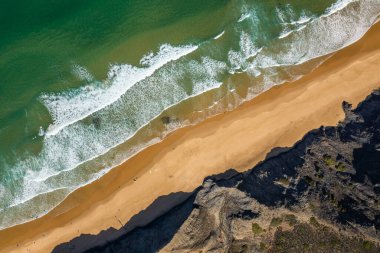 Aerial drone view of Cordoama Beach in Portugal with sandy shore, cliffs and ocean clipart