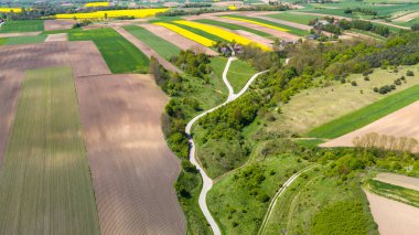Grodzisko Stradow ortaçağ yerleşimi ve Polonya 'nın Ponidzie bölgesindeki kıvrımlı kırsal yol. Drone görünümü