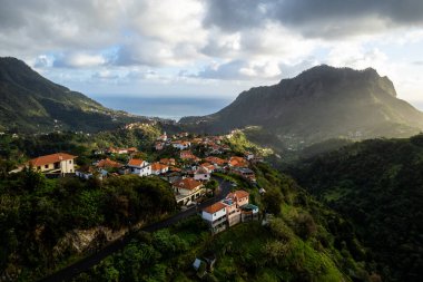 Madeira Adası manzarası, tepelerdeki küçük köy ve yeşil yemyeşil orman. Hava aracı görüntüsü. Portekiz seyahati.