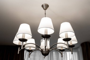 Birkaç lambadan oluşan yuvarlak bir avize. Açık tavan, tam çerçeve, yan görüş. yatay çerçeve