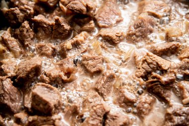 Yakın plan güzel büyük et parçaları ve tavada soğan.